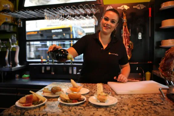 Cristina Valderas con las cinco tapas del 'Panaceite', uno de los bares que participan en la ruta. 