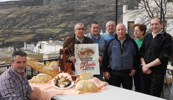 Empresarios de Capileira junto al popular plato y al pan y vino de la zona.