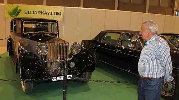 Un hombre observa atentamente el Rolls Royce expuesto del año 35.  