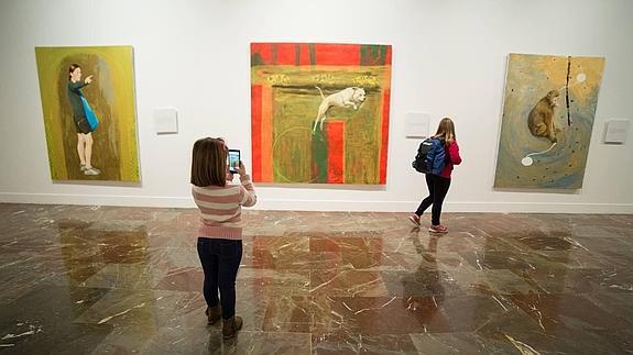 Dos niñas observan la exposición 'Un cuento chino' del pintor granadino Juan Vida.  