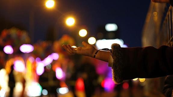 Una mano extendida para coger caramelos durante la cabalgata de los Reyes Magos. 