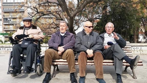 Ángel, Antonio, Juan y Manuel debaten en un banco del parque sobre el lanzamiento de la pava.