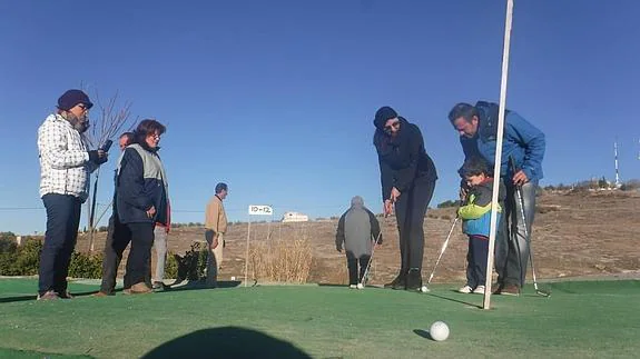 Un niño aprende a jugar al golf.