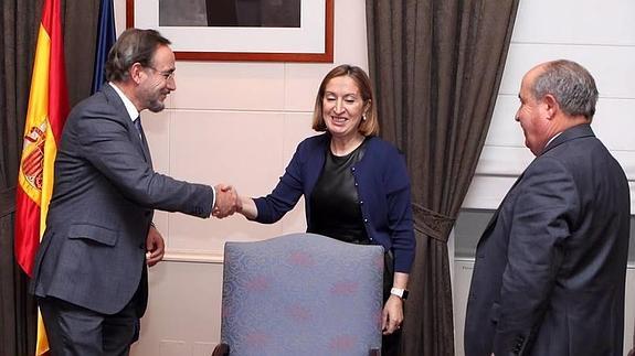 El consejero estrecha la mano de la ministra en presencia del alcalde de Granada.