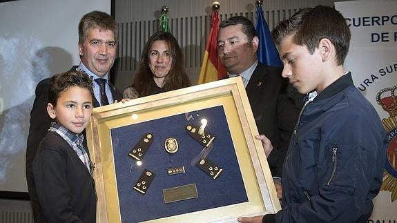 El director general de la Policía, Ignacio Cosidó (2i), y el delegado del Gobierno en Andalucía, Antonio Sanz (2d), junto a Gema de los Ríos, viuda de Jorge García Tudela, y sus dos hijos.