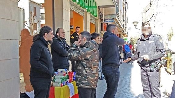 Un agente habla con los jóvenes que pedían alimentos.