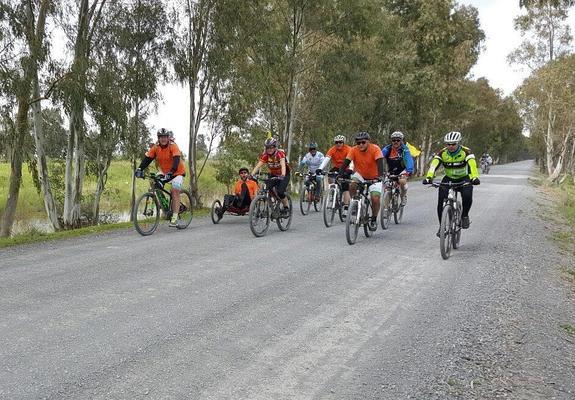 La caravana del Reto por la ELA acompaña a Jorge Abarca (segundo por la izquierda) en su llegada a Sanlúcar de Barrameda.