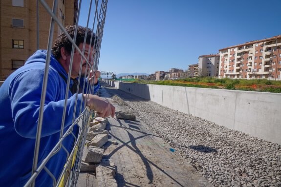 El portavoz de la Marea Amarilla se asoma a la valla y contempla el muro de contención de las vías del AVE.