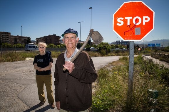Miguel y Mari Ángeles, en un carril limítrofe con su finca, con la circunvalación al fondo.