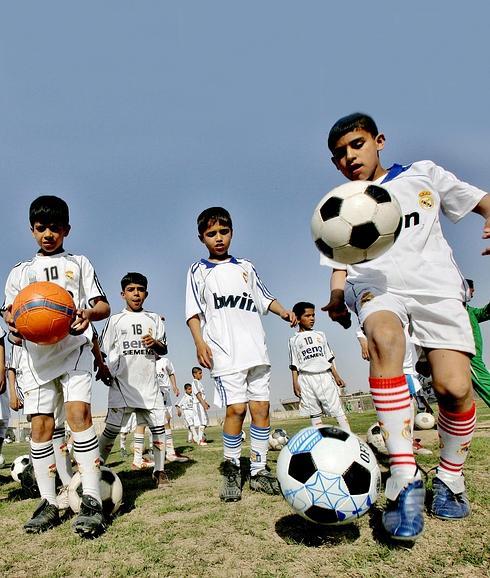 Niños iraquíes vestidos con la equipación del Real Madrid entrenan en una escuela de fútbol en Bagdad, la capital de Irak.