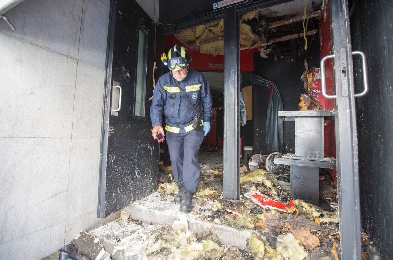 Un especialista en investigación de incendios sale de la sala de música tras inspeccionar ayer el local que sufrió el incendio.