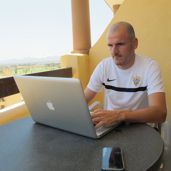 Fernando Soriano en la terraza de la habitación que ocupa en el Hotel Senator Mar Menor viendo el vídeo del UDA-UCAM Murcia.