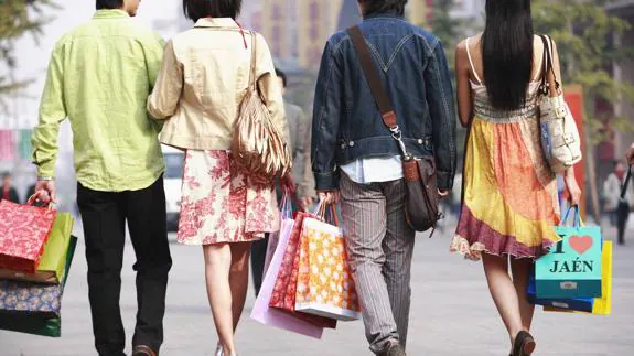 Dos parejas pasean tras un día de compras por Jaén. 