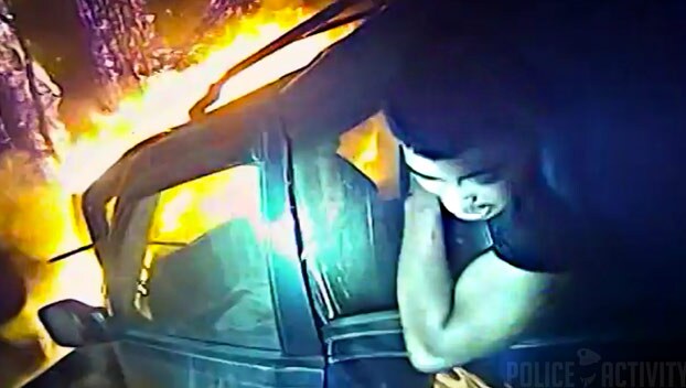 Un policía graba con su cámara cómo salva a un chico atrapado en un coche en llamas