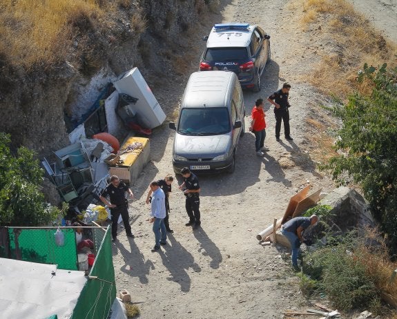 La detenida, sentada a la izquierda, mientras los agentes de la Policía Nacional rastrean la zona en busca de un arma blanca.