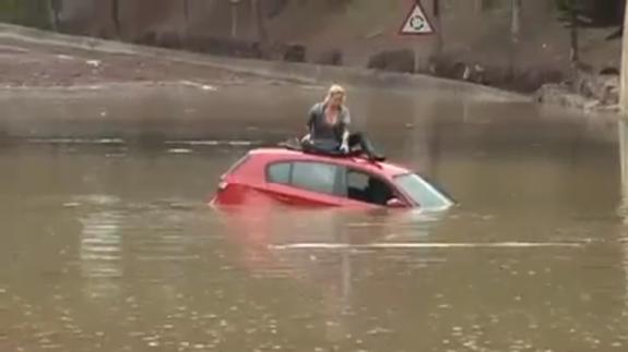 Los bomberos rescatan a una joven atrapada en una carretera inundada
