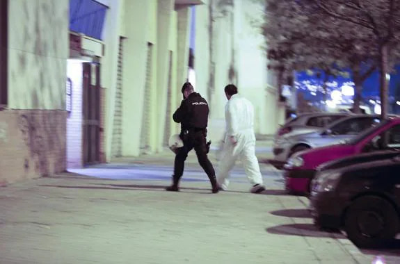 Un agente de Policía Científica y un funcionario policial, antes de entrar al edificio donde se encuentra el piso de la fallecida. 