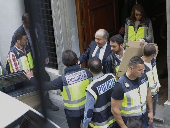 Torres Hurtado se monta en el coche policial tras el registro de su despacho.