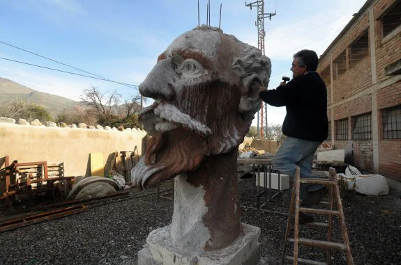 El escultor, trabajando en el enorme busto.