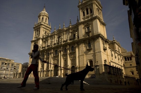 Una niña pasea con su perro delante de la Catedral de Jaén.