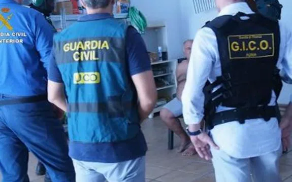 Agentes italianos y de la Guardia Civil con un detenido.