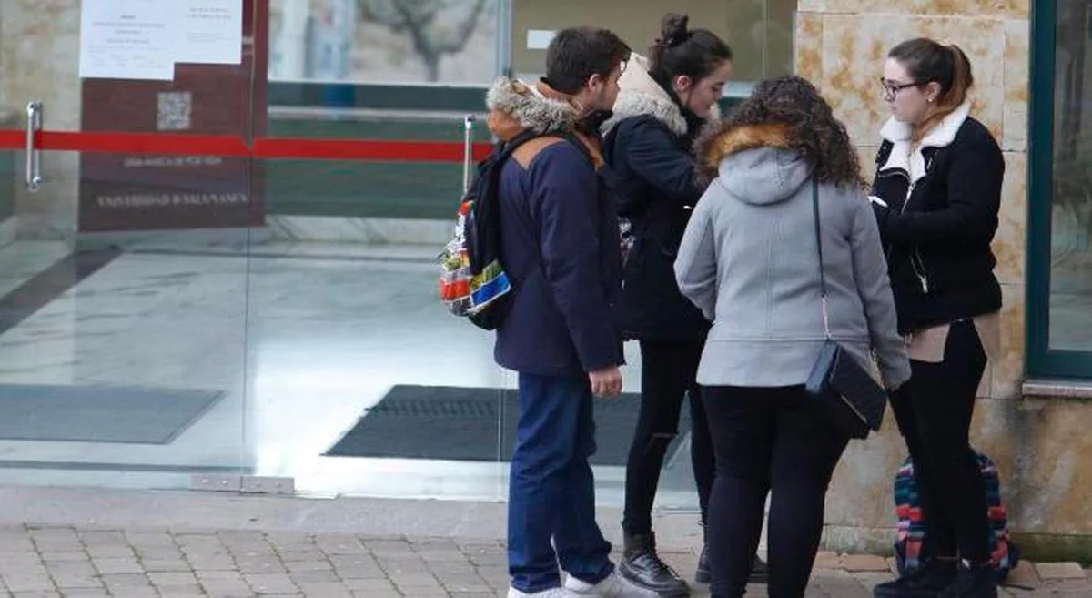 Cuatro jóvenes charlan a las puertas de la facultad de Biología de la USAL.