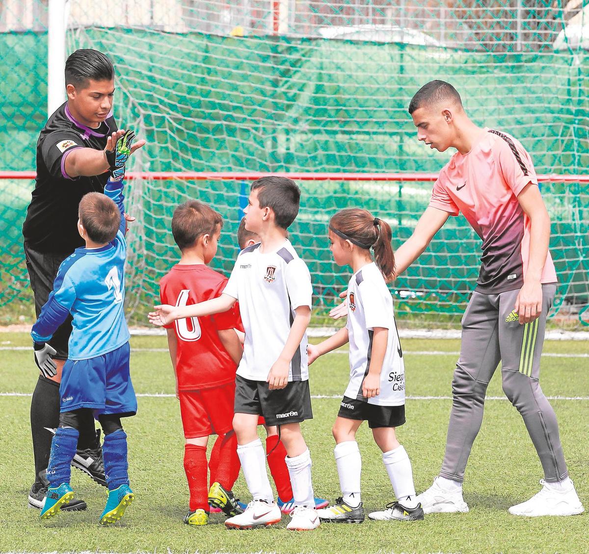 Saúl, portero del Hergar D prebenjamín, choca los cinco al colegiado Brian Escudero al término del partido ante el Ciudad Rodrigo.