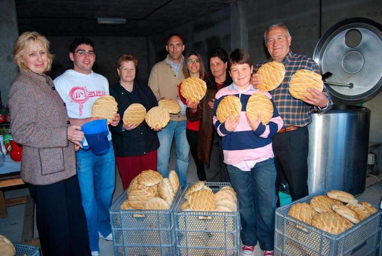 La familia de uno de los mayordomos muestra los panes que se entregarán a los cofrades de Navales.