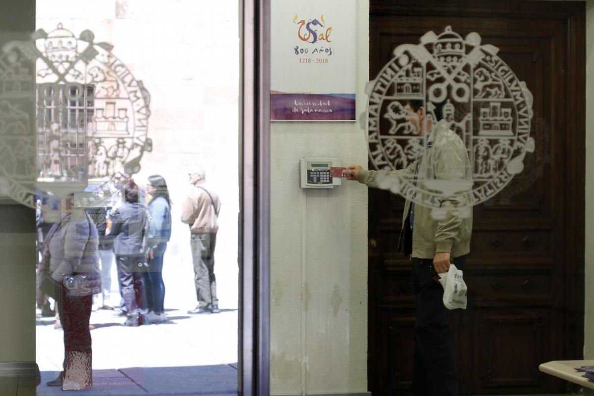 Un trabajador de la Universidad de Salamanca ficha al salir de su puesto a mediodía.