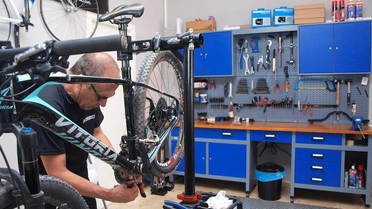 Un técnico reparando una bicicleta.