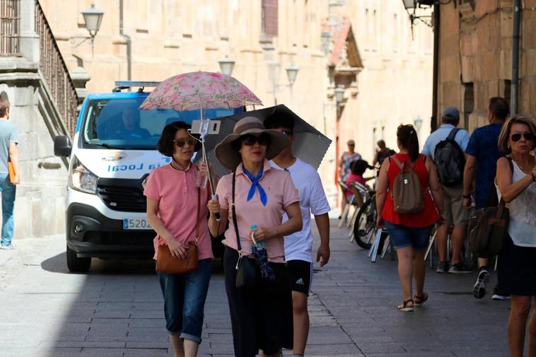 Turistas protegiéndose del sol en Salamanca.