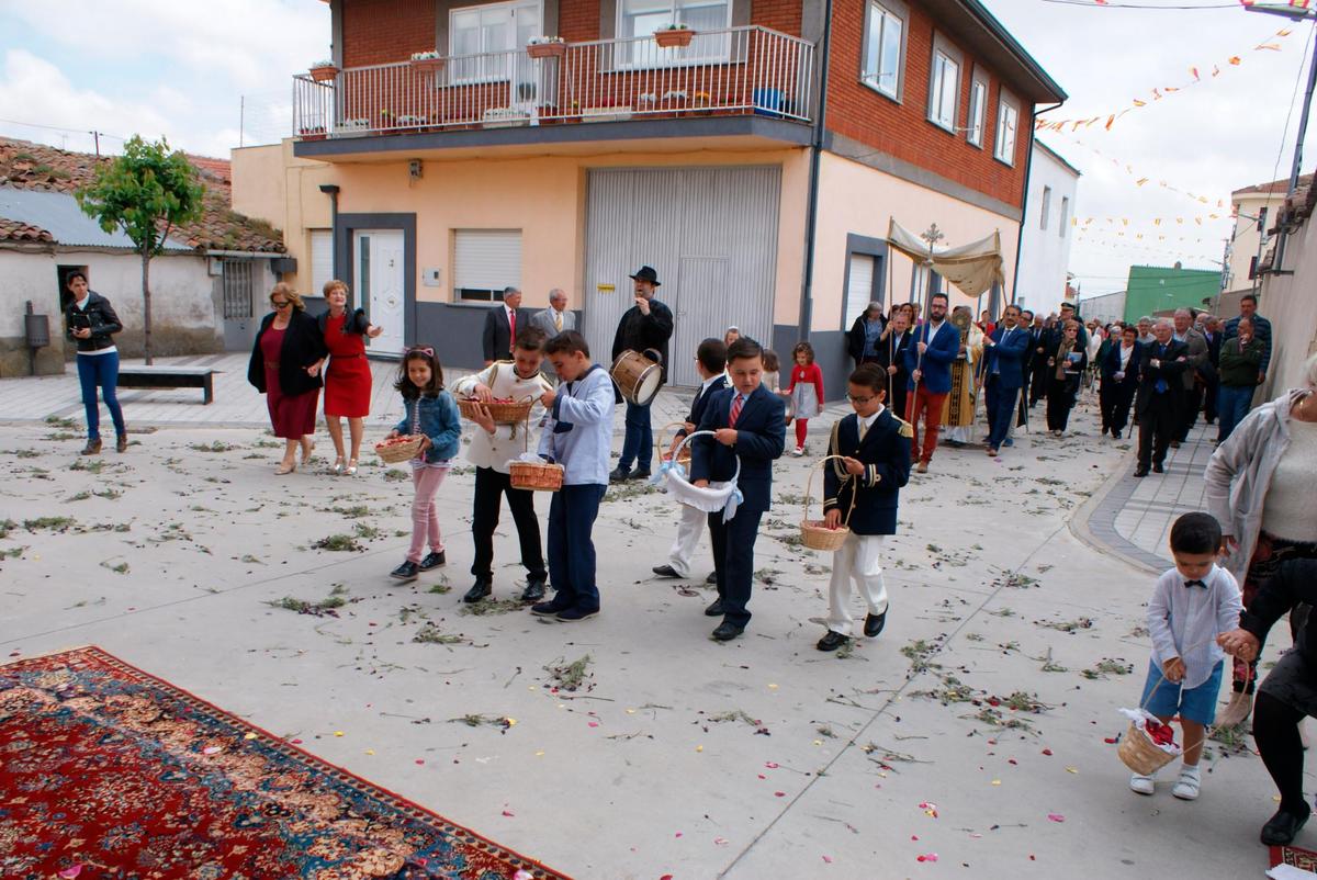 Los niños arrojando los pétalos de flores antes del paso de la procesión de Corpus
