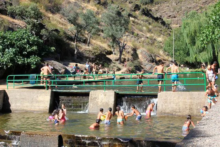 Bañistas disfrutan de un día soleado en las piscinas naturales de Valero.