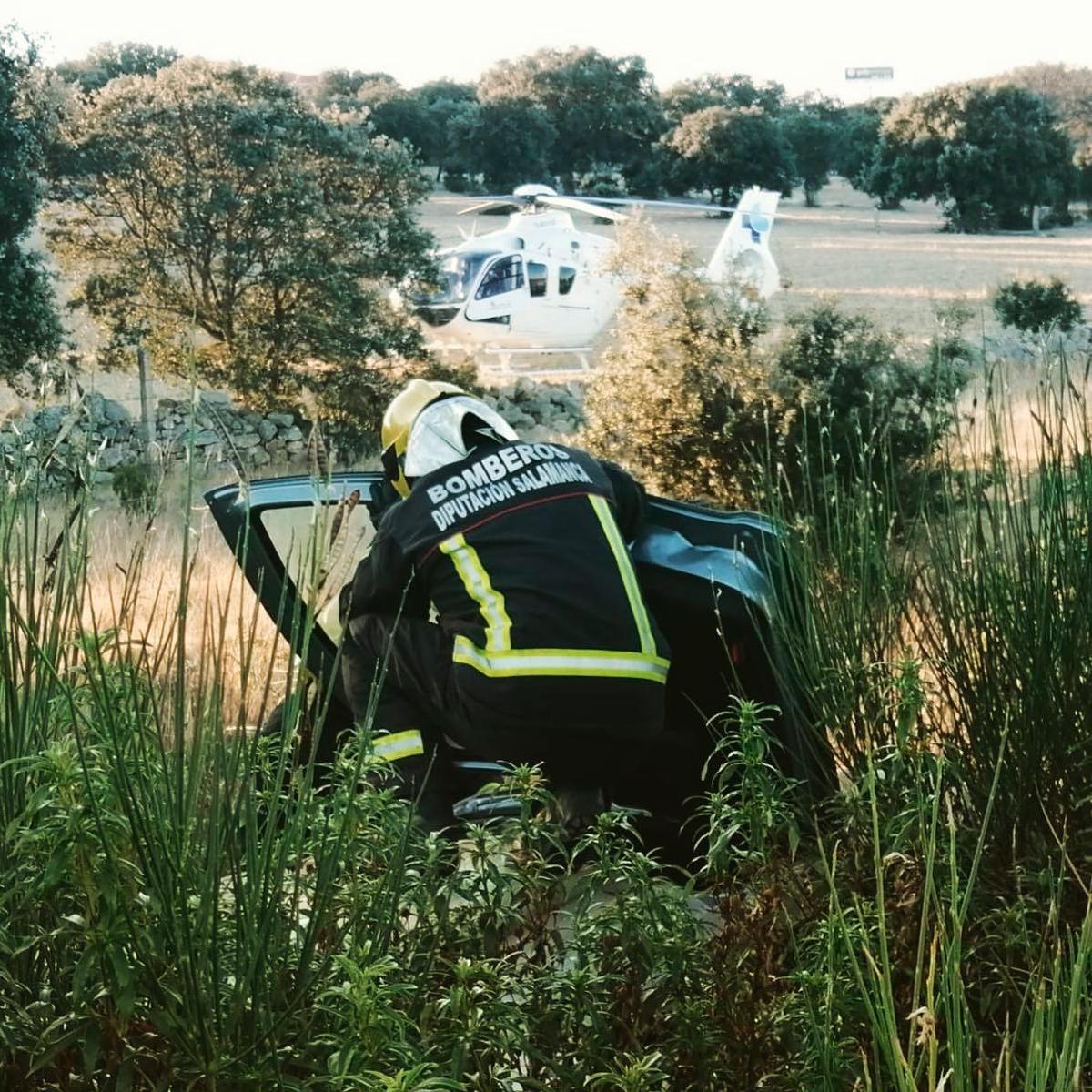 Un bombero junto al coche siniestrado.