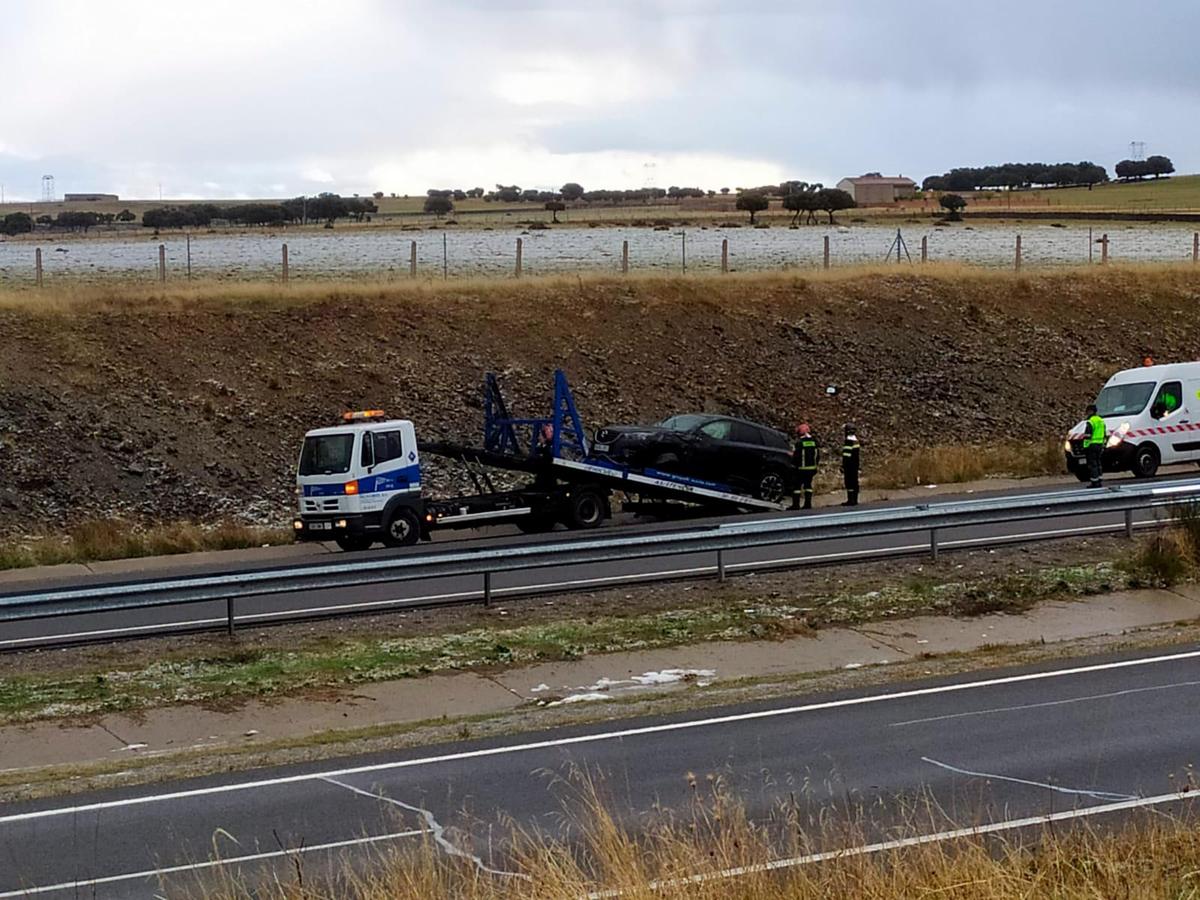 El vehículo siniestrado recogido por la grúa.