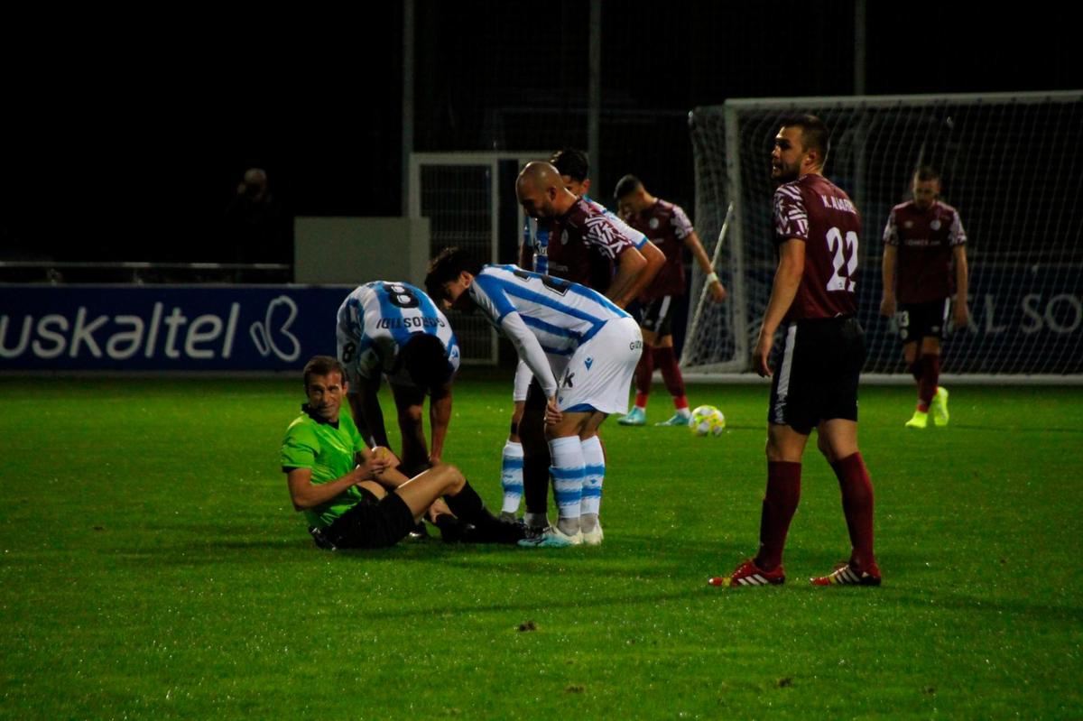 El colegiado, tendido sobre el terreno de juego de Zubieta.