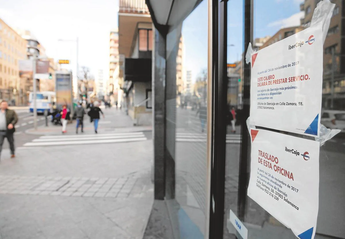 Carteles de cierre y traslado de cajeros en una oficina de Salamanca.