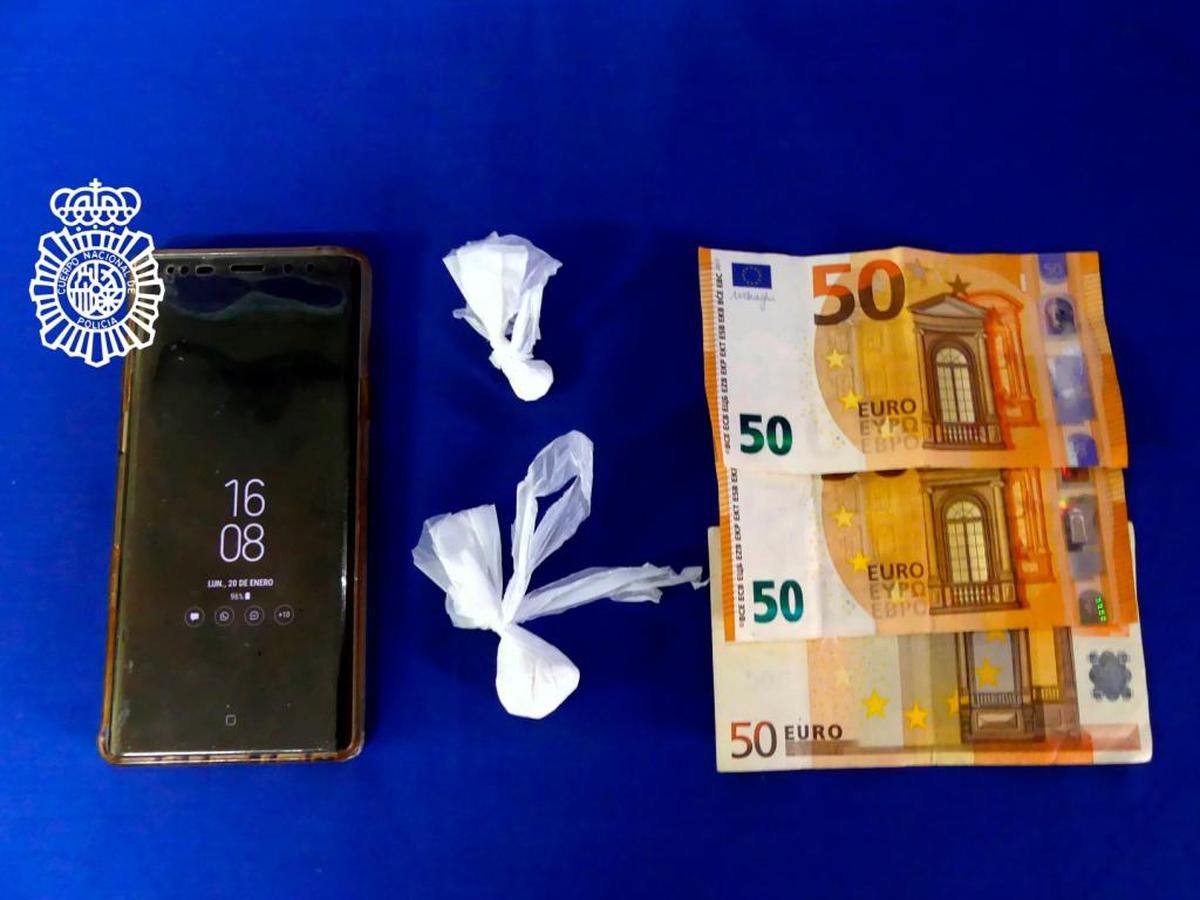 Las dos bolsas de cocaína junto al móvil y algunos billetes que se le incautaron a la mujer.