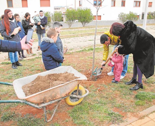 Una familia planta uno de los árboles del ‘Bosque de los Niños’ en Doñinos.