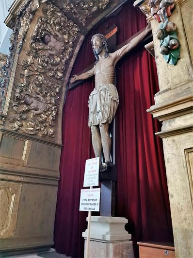 La talla del Cristo de Cabrera con los carteles para no tocarlo ni besarlo.