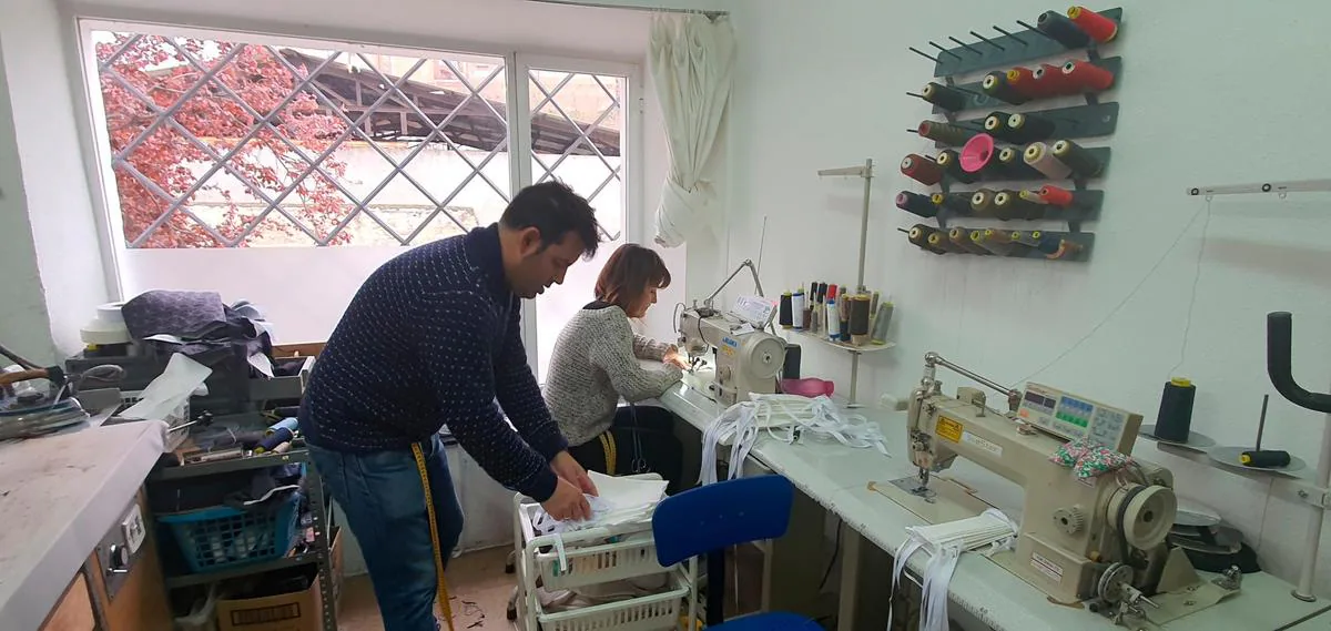 El sastre Raúl Rodríguez junto con Ana Hernández preparan mascarillas de algodón en su taller