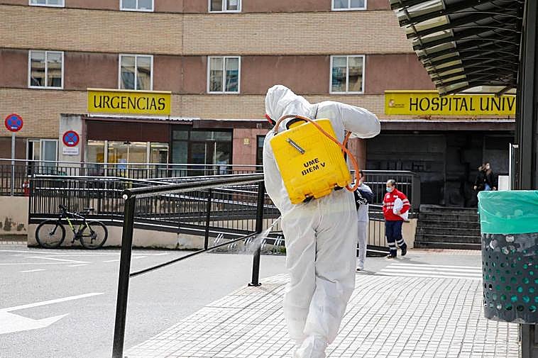 Personal desinfectando los accesos del Clínico.