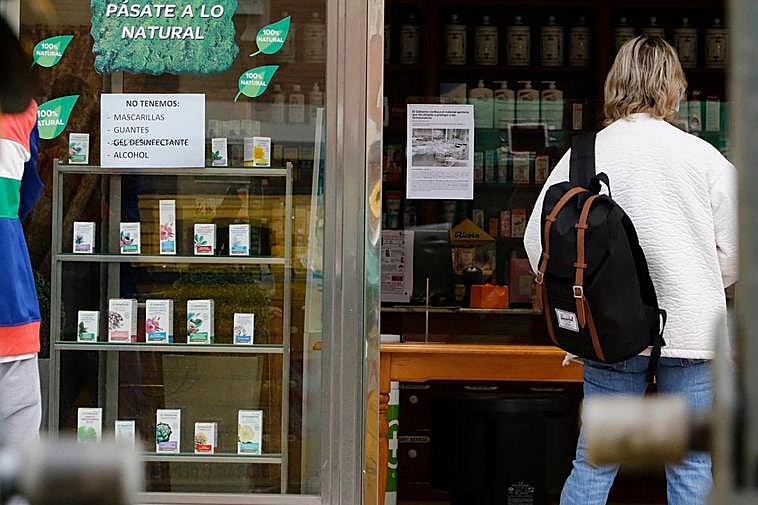 Cartel en el escaparate de una farmacia anunciando que no disponen de mascarillas, guantes ni alcohol