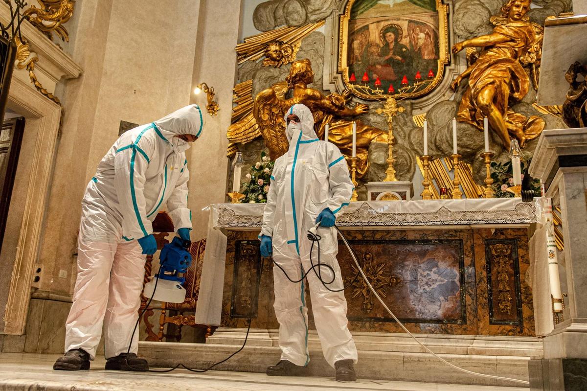 Dos trabajadores desinfectan una iglesia en Roma.