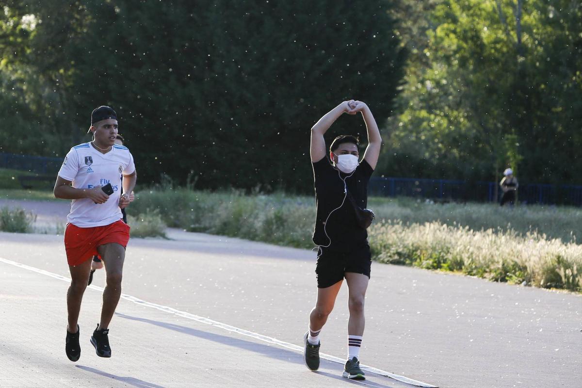 Dos jóvenes hacen deporte mientras circulan numerosas partículas de polen por el aire.