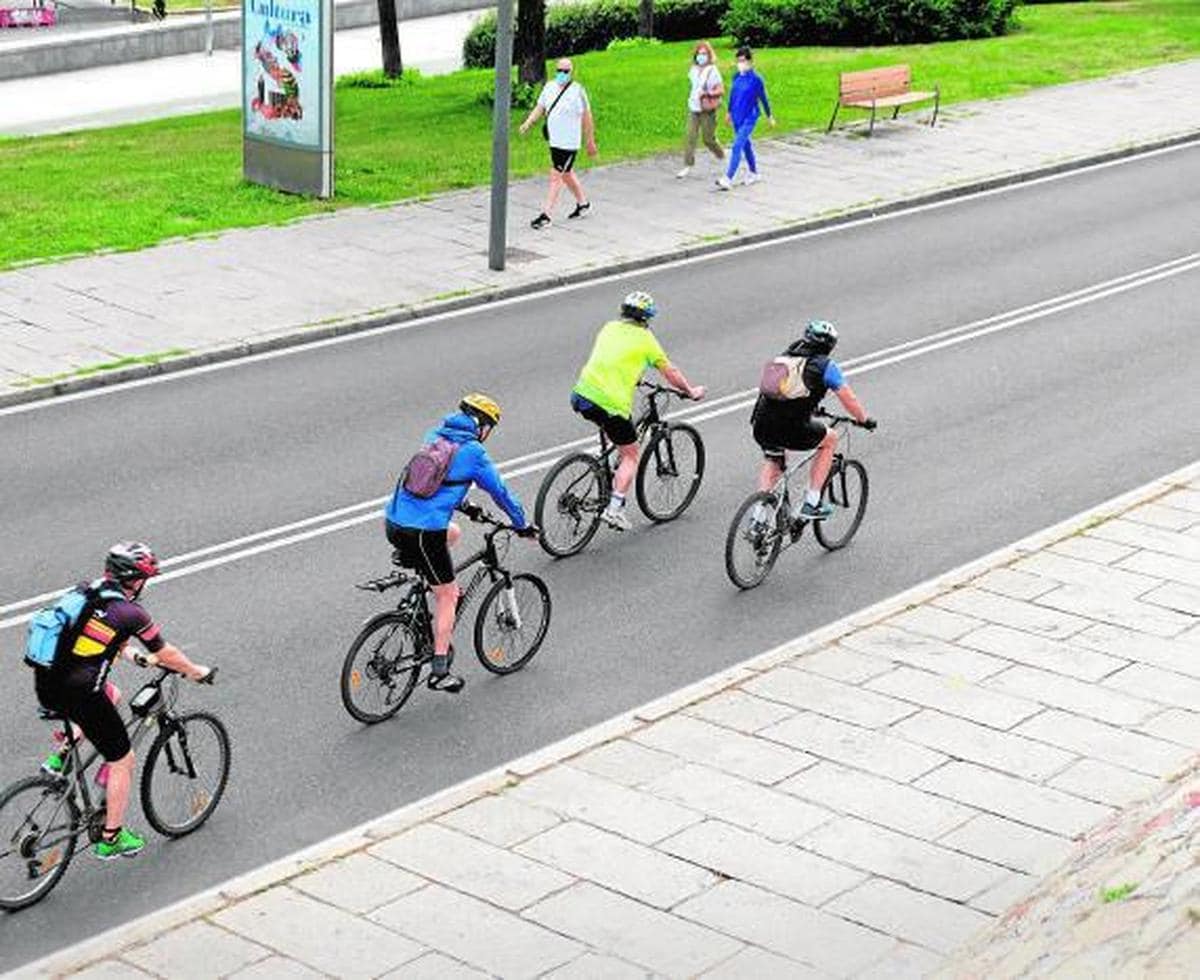 Varios cicloturistas pasean con sus bicis en la franja horaria.