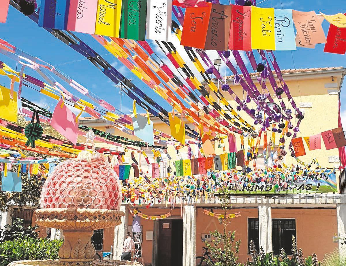 La plaza de la localidad ha sido decorada con cientos de cadenetas y pompones