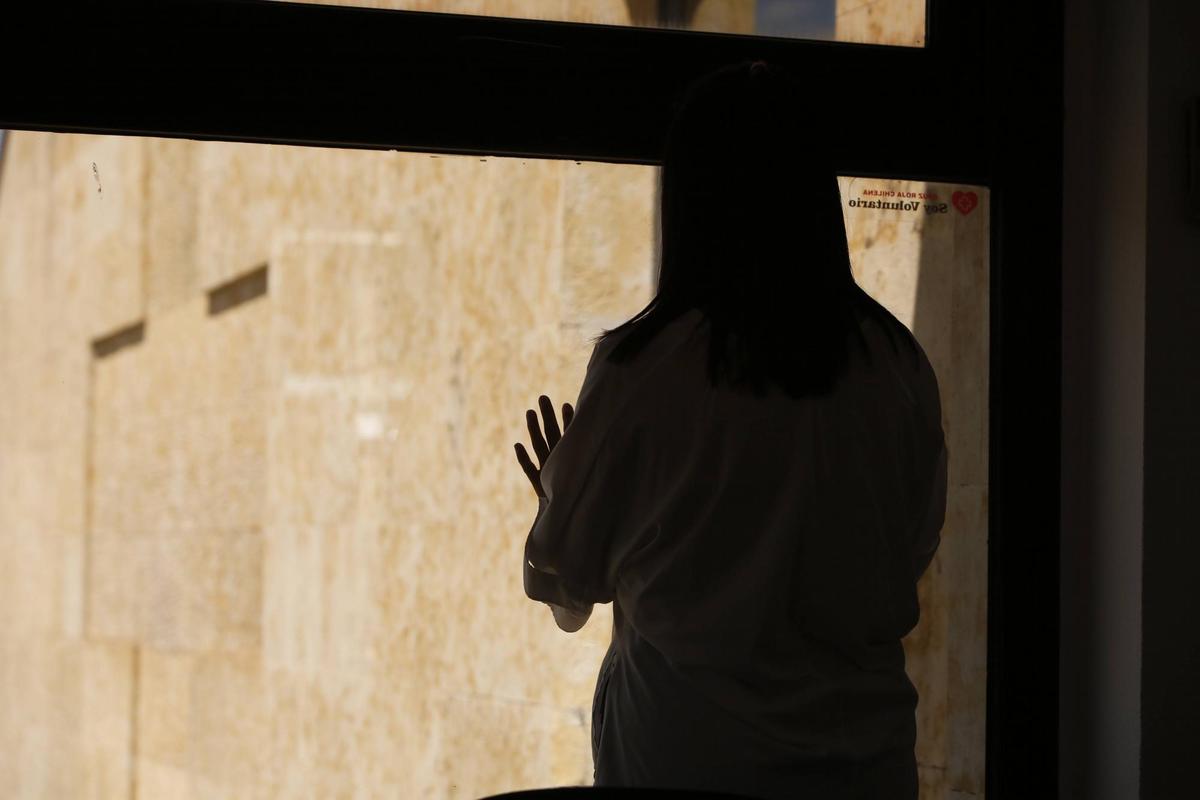 María mira por la ventana en una estancia del edificio de Cruz Roja Salamanca.