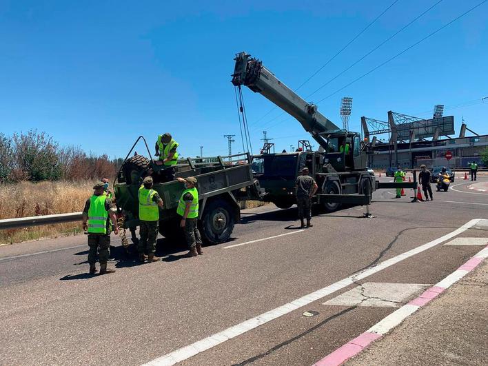 Varios militares ayudan a la retirada del remolque volcado