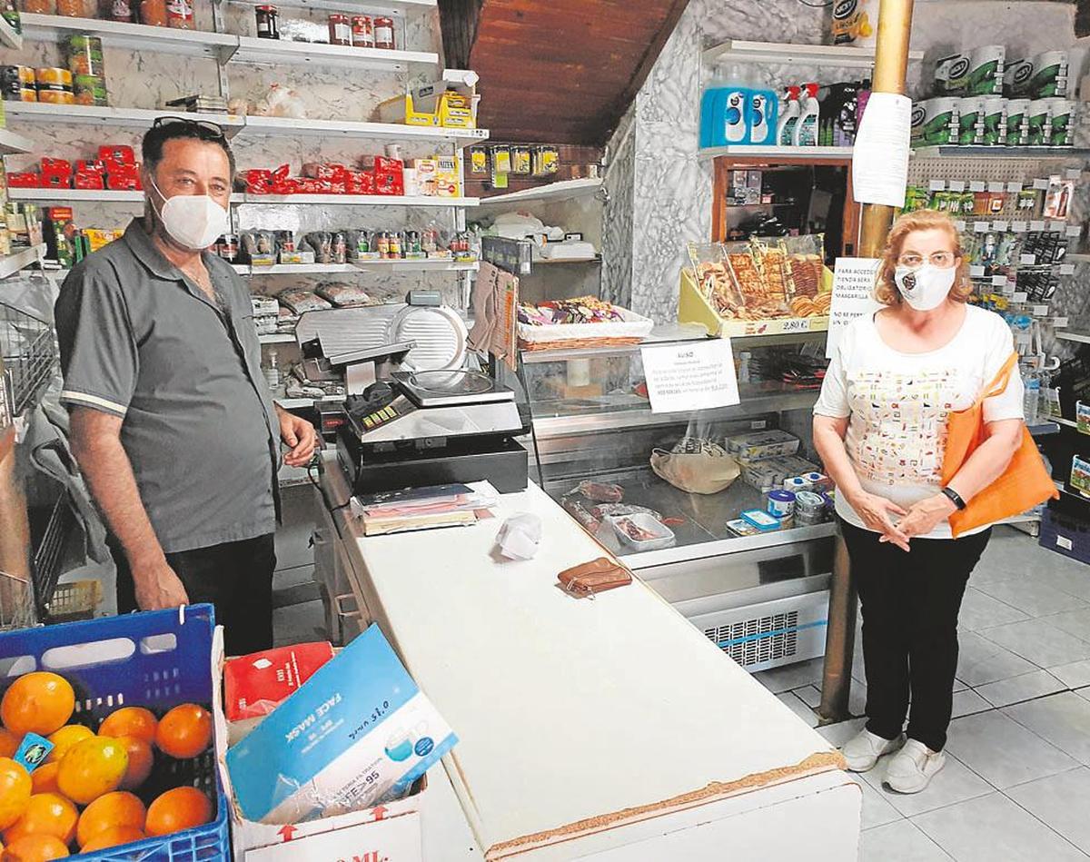 Juan Martín con una clienta en su comercio de La Zarza de Pumareda.